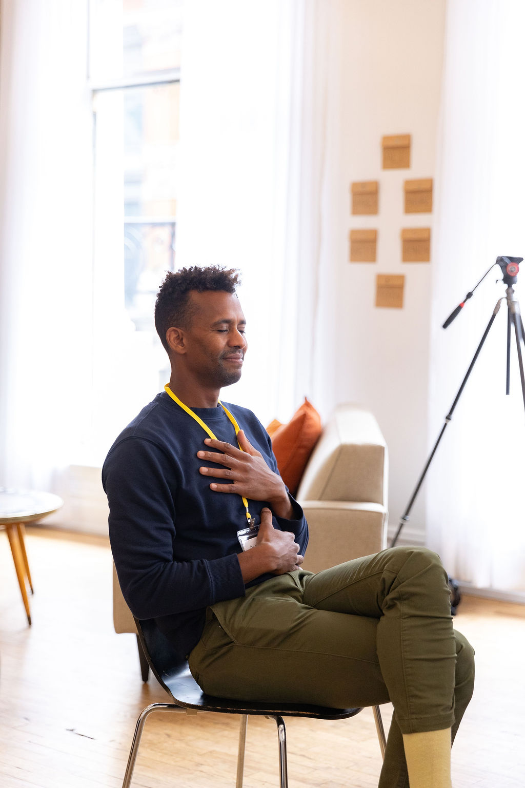 Andre Essue seated with his eyes closed and a hand resting on his chest during a quiet moment in a session.